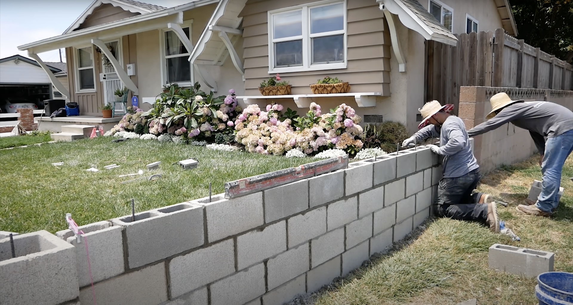 Concrete Block Wall Installation Services Concrete masonry workers installing decorative block wall for residential landscaping